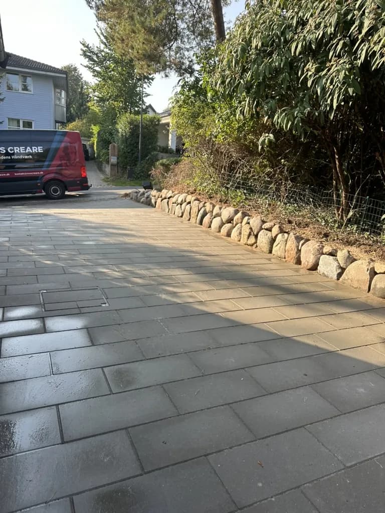 Betonbelægning - Ny indkørsel i betonbelægning med stengærde som kant. Komplet med dræn og korrekt afvanding mod vej.