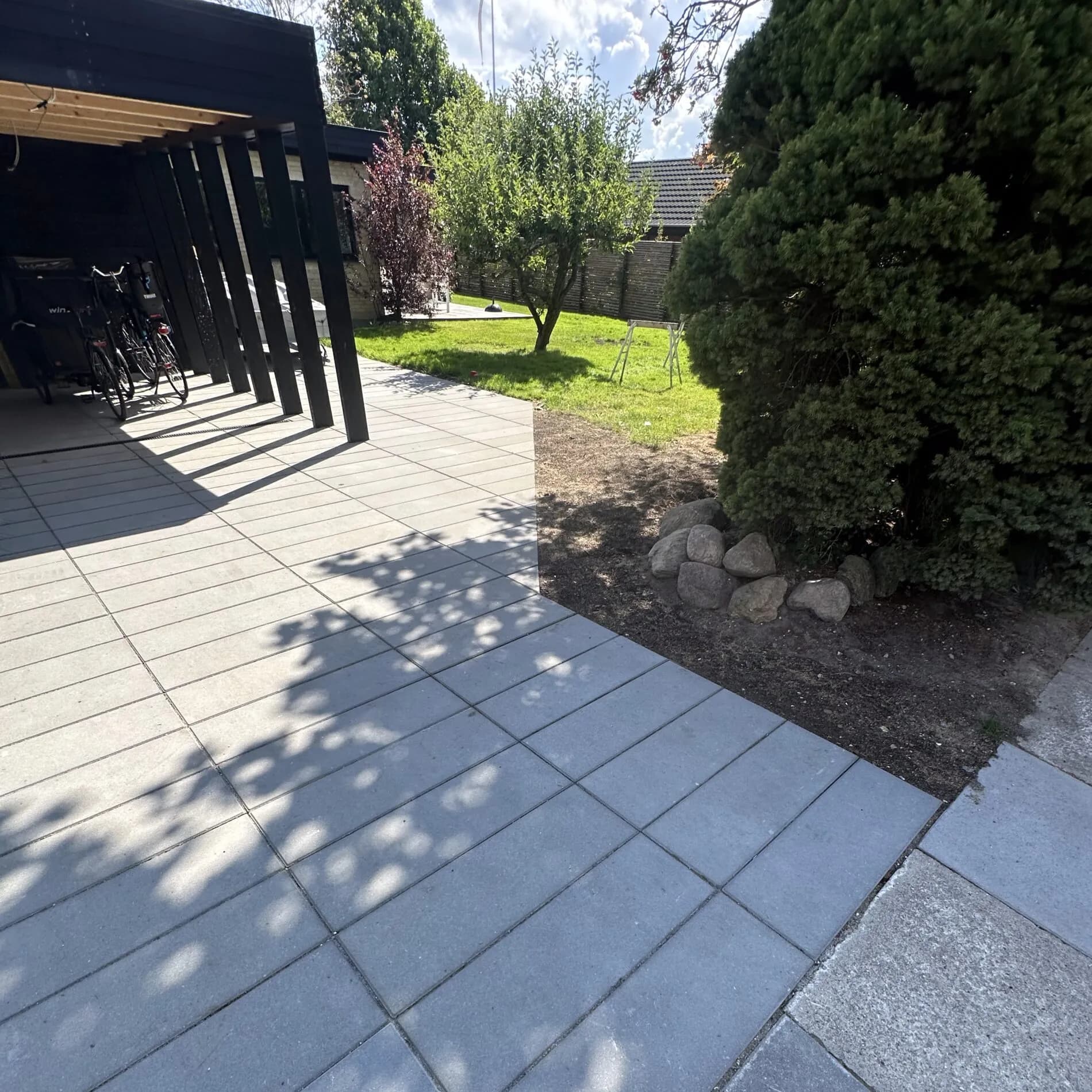 Flisebelægning - Soldaterfliser lagt i forbandt til carport og havegang. Stabil bund med afrettet grus og kantsten i beton.